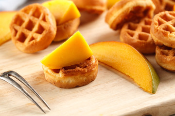 circle mini waffles with mango on wooden cutting board