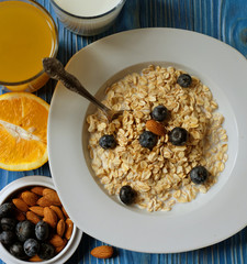 Healthy eating, food and diet concept - tasty oatmeal with berries and glass of orange juice.