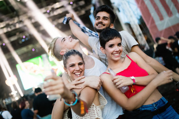 Happy friends having fun at music festival