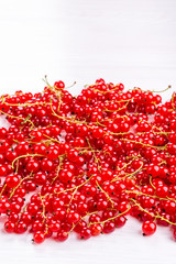 Fresh red currant berries on white table.