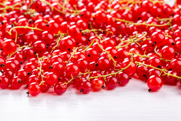 Fresh red currant berries on white table.