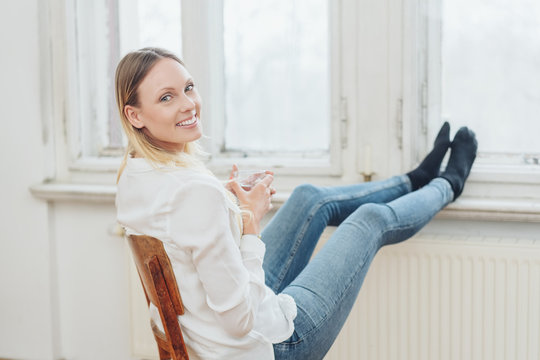 Young woman with her stockinged feet on a radiator