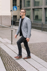 Trendy middle-aged man walking through town