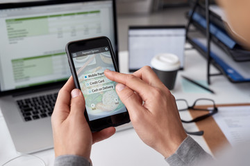 Hands using mobile phone app to order food