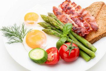 Fried eggs with bacon on the wooden table.
