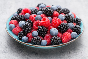 Fresh raspberries in a plate on a  vintage background.