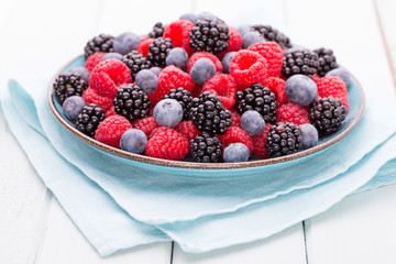 Fresh raspberries in a plate on a  vintage background.