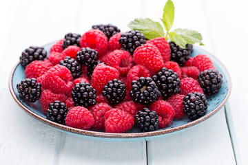 Fresh raspberries in a plate on a  vintage background.