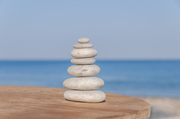 Fototapeta na wymiar Several Zen stones stress balanced on blurred sea and beach