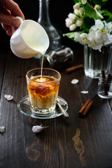 A glass of black tea with milk