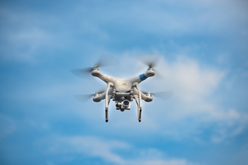 White Drone with Camera Flying in Blue Sky. UAV Concept