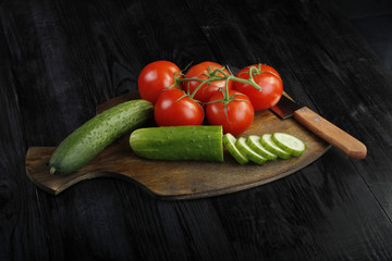 tomatoes and cucumbers on wooden background