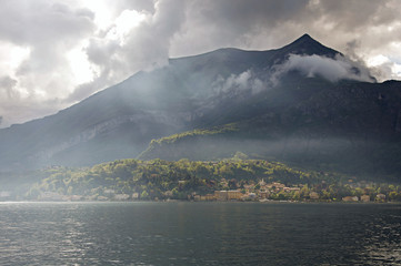 Close-up of Lake Como in a cloudy day with sunshine in Bellagio, a charming tourist village between the lake and the mountains of the Alps. Located in the Lombardy region, northern Italy