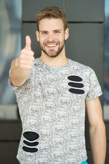 Man with beard or unshaven guy in stylish shirt shows thumb up. Man with bristle on smiling face in...