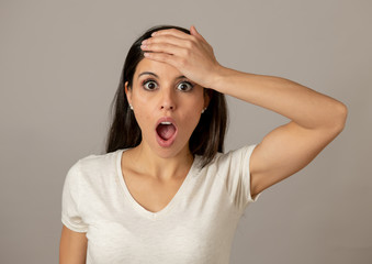 Young attractive woman with a surprised and shocked face, eyes and mouth wide open.