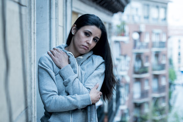 Obraz premium Portrait of a young attractive woman with depression looking unhappy and hopeless on a balcony.