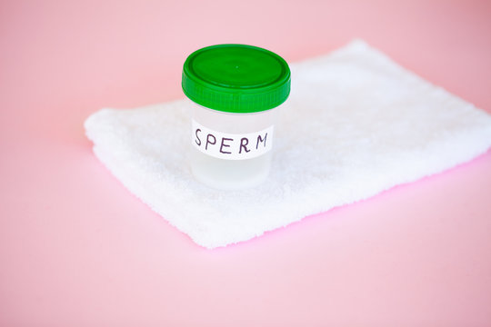 Health. Close up Sperm Analysis. Concept of Bank Sperm. Infertility Bank with Sperm on Pink Background with Towel.