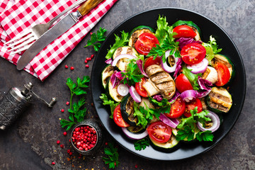 Salad with fresh and grilled vegetables and mushrooms. Vegetable salad with grilled champignons. Vegetable salad on plate. Healthy vegetarian food