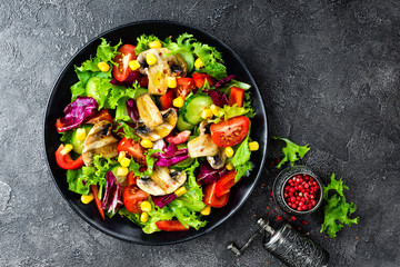 Salad with fresh and grilled vegetables and mushrooms. Vegetable salad with grilled champignons. Vegetable salad on plate. Healthy vegetarian food