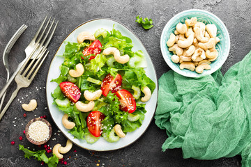 Salad with fresh vegetables and nuts. Vegetable salad with fresh vegetables and cashew. Vegetable salad on plate. Healthy vegetarian food