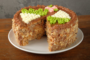 Cut homemade Kiev cake on old wooden table. The known ukrainian bakery products. Close-up view.