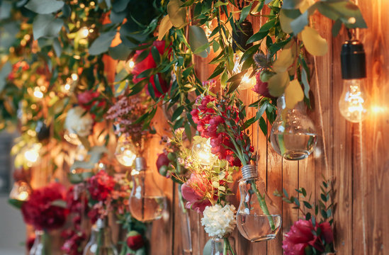 Rustic wedding photo zone. Hand made wedding decorations includes Photo Booth  red flowers. Garlands and light bulbs
