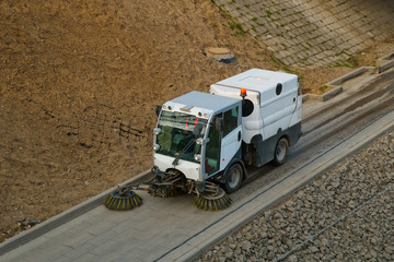 Street cleaning sweeper truck on the road. Top view.