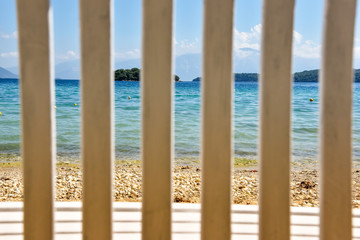 abstract romantic landscape with the sea through the bars of the back of the wooden bench.