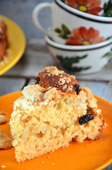 Slice of yeast cake with crumble on an orange saucer