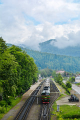 Train at the station on the background of the Carpathians. Passenger train in the Carpathians Mountains village. Ukraine