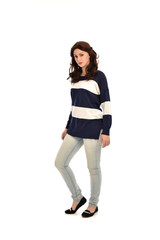 full length portrait of girl wearing striped blue and white jumper and jeans. standing pose on white studio background