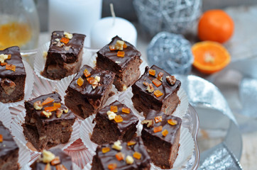 Square pieces of apple cake with chocolate glaze on a glass plateau