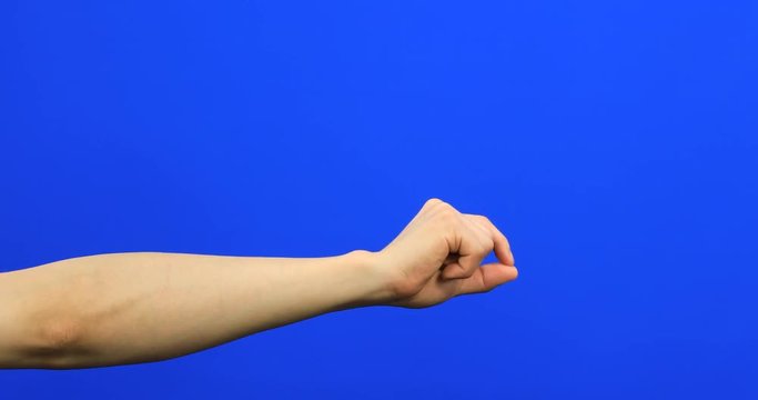 Male fingers grabbing and pulling something invisible toward him on blue screen