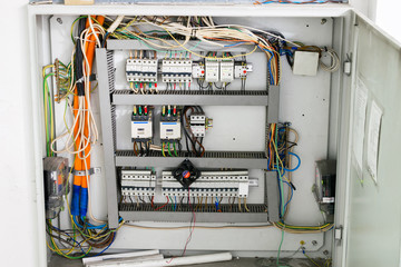 The open electrical box contains many wires, electromagnetic relays and high voltage switches