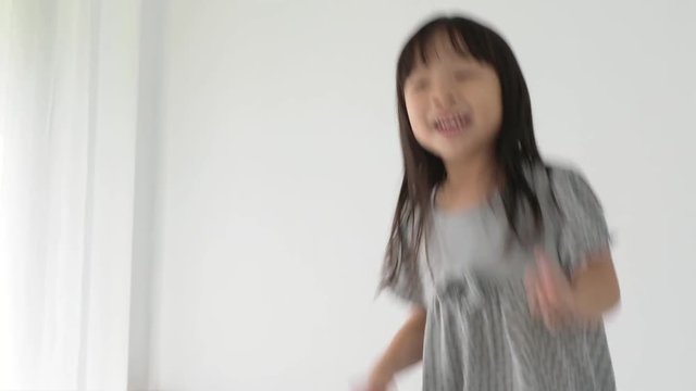 Little asian girl having fun dancing in a room at home 