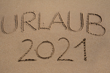  Das Wort Urlaub 2021 in den Sand geschrieben