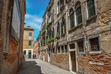 Fototapeta premium View of old buildings in an alley with blue sky in the city center of Venice, the historic and amazing marine city. Located in Veneto region, northern Italy