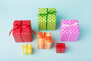 Group of colorful holiday gift boxes on blue background.