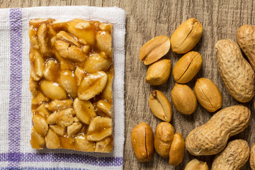 Candy with peanut: Pe de Moleque in Brazil and Chikki in India. Sweet food of Festa Junina, a typical brazilian party. Snack over wood table.