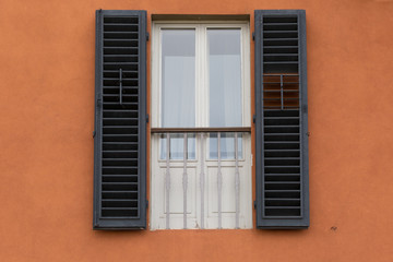 Fototapeta na wymiar window shutters on orange wall, Burano, Venice