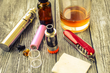 Still life with e-cig and jiuce on the wooden background