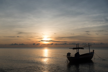 Fototapeta na wymiar Fishing boat on the beach in the morning with sun rise.