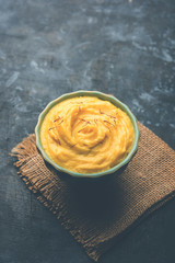 Amrakhand OR Mango Shrikhand / srikhand is popular Indian dessert served with saffron toppings in a bowl