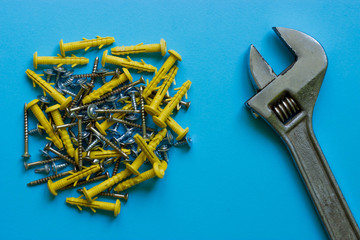 A bunch of different nails and a wrench on a blue background