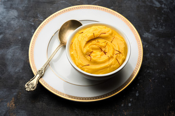 Amrakhand OR Mango Shrikhand / srikhand is popular Indian dessert served with saffron toppings in a bowl