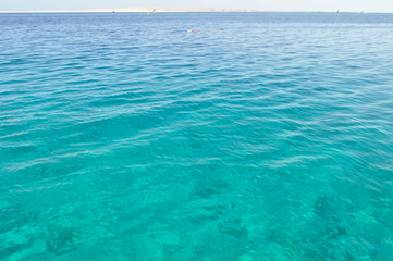 azure coast with white sand, clean and clear blue water on a sunny day