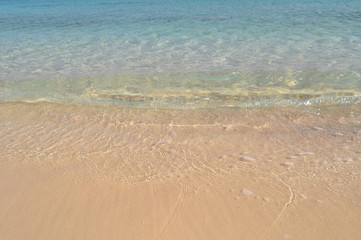 azure coast with white sand, clean and clear blue water on a sunny day