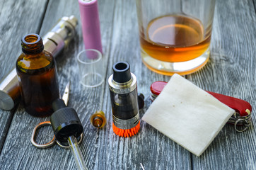 Still life with e-cig and jiuce on the wooden background