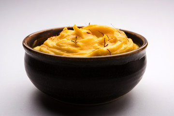 Amrakhand OR Mango Shrikhand / srikhand is popular Indian dessert served with saffron toppings in a bowl