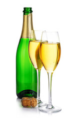 Two elegant champagne glasses on the background of green bottles close-up isolated on  a  white. Festive still life.